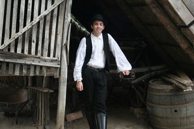 Portrait of smiling young man standing against built structure