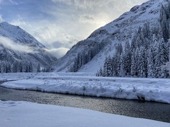 Scenic view of snowcapped mountains by lake against sky