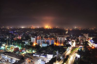 Illuminated cityscape against sky at night