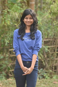 Portrait of smiling young woman standing outdoors