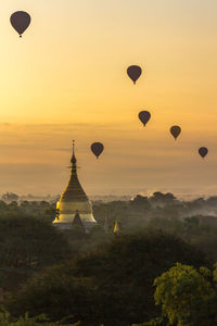 Hot air balloons in sky at sunset