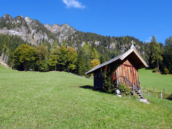 House on countryside landscape against blue sky