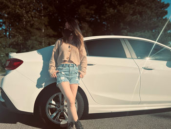 Side view of woman standing in car