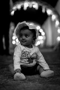 Portrait of cute baby girl sitting at night