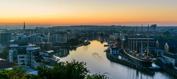 High angle view of river and buildings against sky during sunset
