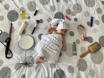 Newborn baby surrounded with cosmetic stuff