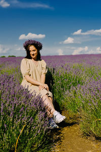 Portrait of young woman sitting on field