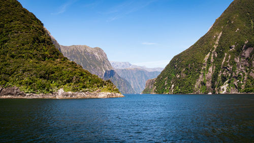 Scenic view of sea and mountains against sky