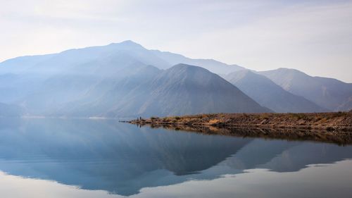 Scenic view of lake and mountains against sky