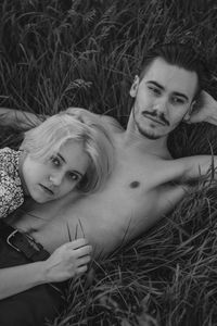 Portrait of young woman lying on field