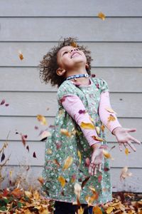 Happy girl standing against the wall