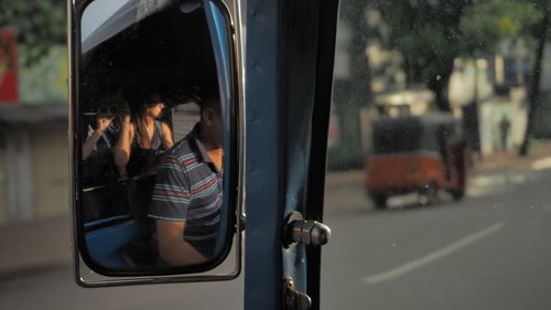 Reflection of woman on car in city