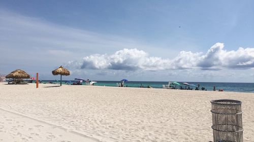 Scenic view of beach against cloudy sky