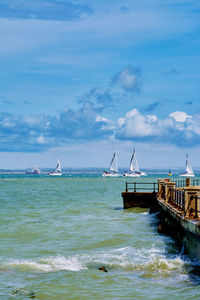 Boats in sea against clear sky