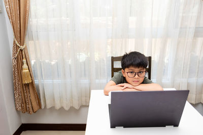 Full length of boy using mobile phone at home