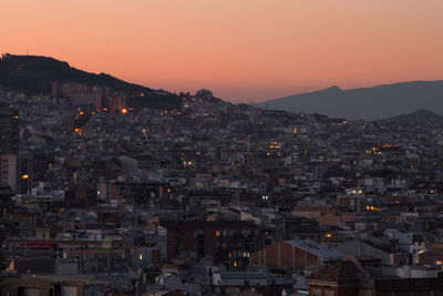 Illuminated cityscape against sky at sunset