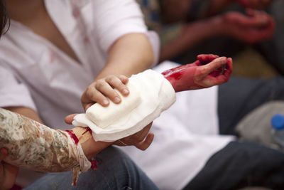 Midsection of nurse examining injured hand