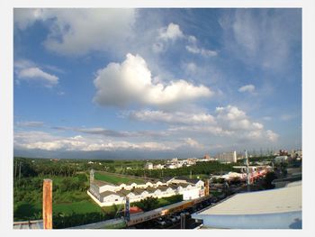 View of cityscape against cloudy sky