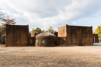 Abandoned building on field against sky