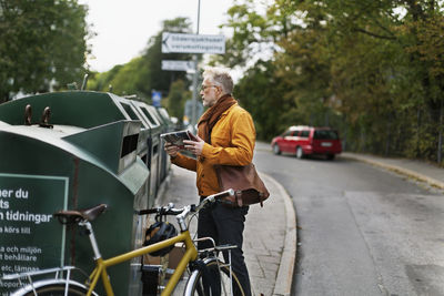 Man putting garbage into recycling bin