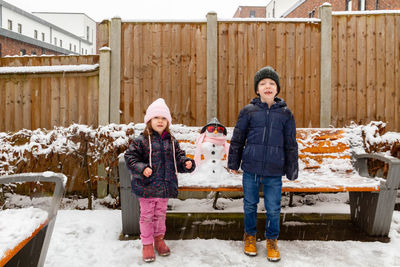 Portrait of boy and girl standing in snow