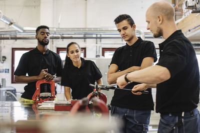 Auto mechanic teacher explaining equipment to students in class