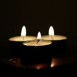 Close-up of lit candle in dark room