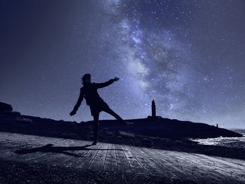 Silhouette man standing on field against sky