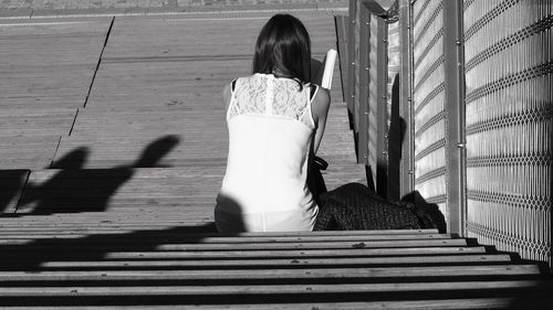 Rear view of woman standing on staircase