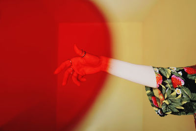 Midsection of woman standing against red wall