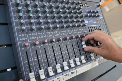 Cropped image of dj adjusting sound mixer