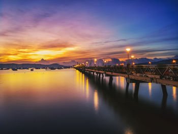 View of bridge over river at sunset