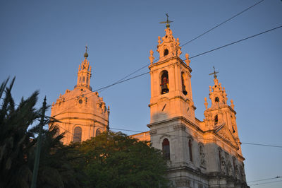 Low angle view of the towers of estrella basilica in lisbon, lapa during early morning sunny day 