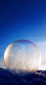 Close-up of bubbles on land against sky