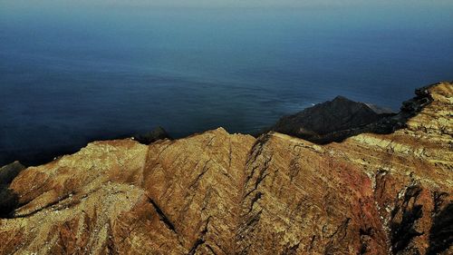 High angle view of rocks by sea against sky