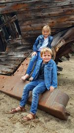 Portrait of friends sitting on wooden floor