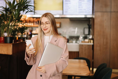 Portrait of a businesswoman entrepreneur with glasses looking at the camera in a public place 