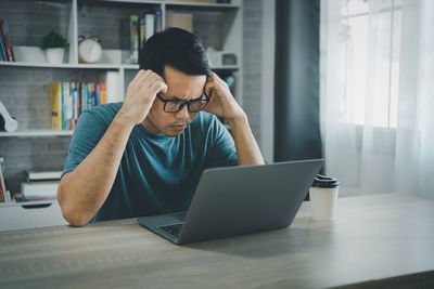 Young woman using laptop at home