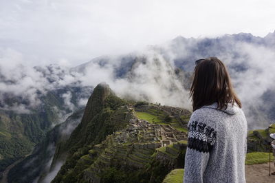 Woman looking at mountains against sky