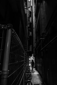 People walking on narrow alley amidst buildings in city