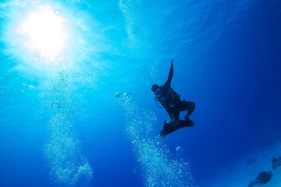 Low angle view of scuba diver swimming in sea