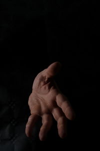 Close-up of human hand against black background