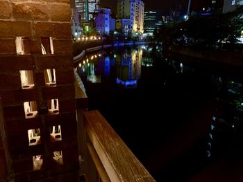 Illuminated buildings by river at night