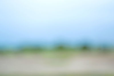 Defocused image of field against clear sky