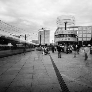 People on street in city against sky