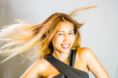 Portrait of young woman against white background