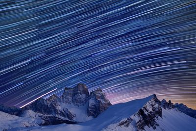Scenic view of snowcapped mountains against sky at night