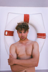 Portrait of young man in front of lifebuoy 