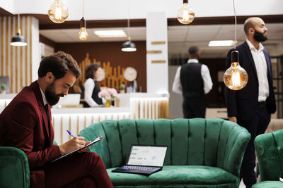 Side view of man using digital tablet in office