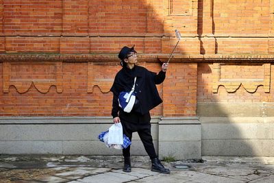 Full length of man standing in front of wall